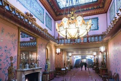 the inside of the long gallery in the royal pavilion brighton, a very grand room with ornate furniture and chandelier