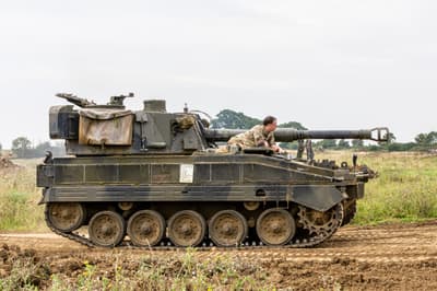 the abbott spg tank being driven across a muddy field on a tank driving experience day
