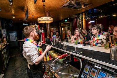 people watching  bartender behind the bar on a cocktail masterclass at revolucion de cuba