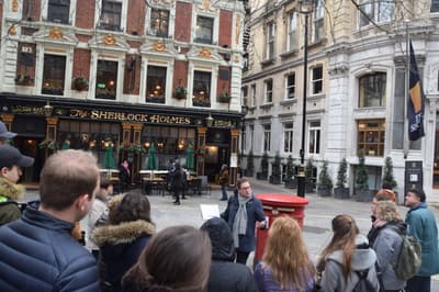 Guide talking to group outside the sherlock holmes pub seen on a sherlock holmes walking tour in london
