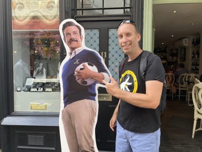 Man posing with cardboard cutout of ted lasso seen on a ted lasso walking tour in london