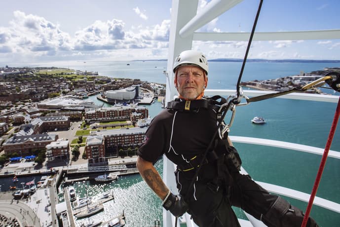 An instructor abseiling down Spinnaker Tower