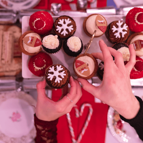 people picking up cakes on a christmas themed afternoon tea bus tour in london