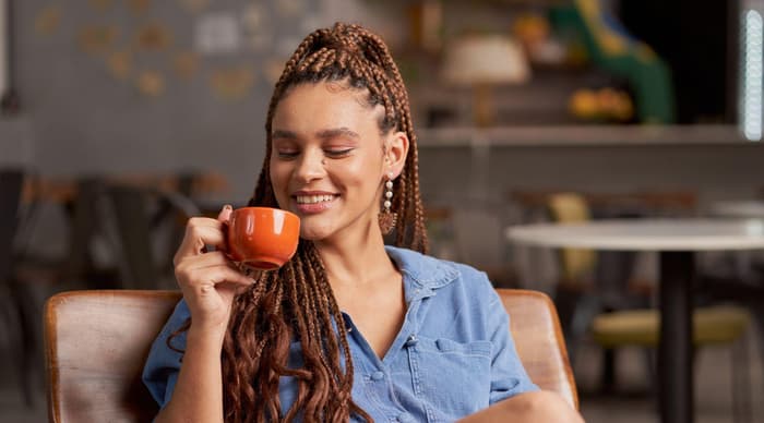 Lady smiling and holding a coffee