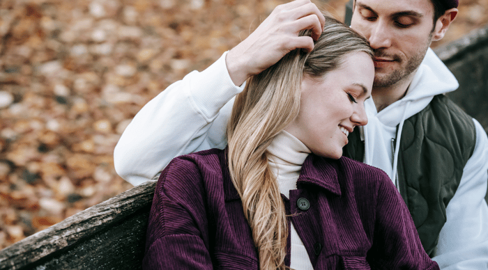 couple sitting on bench in park on valentines day