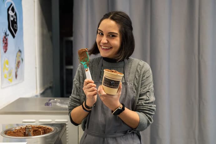 woman smiling and holding a tub of gelato on a learn how to make gelato workshop in london