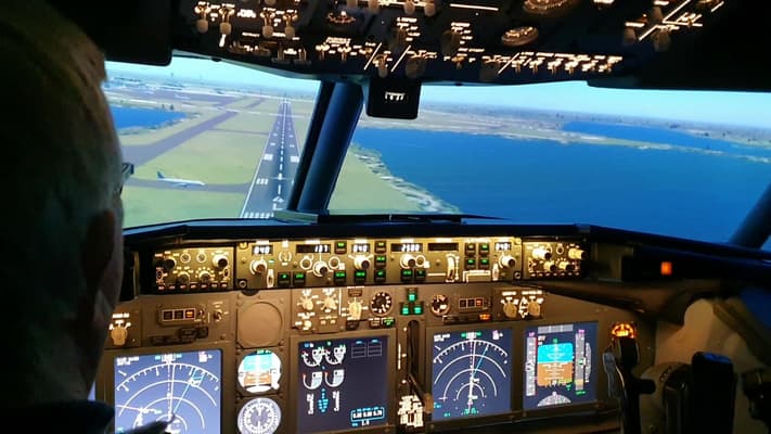 the cockpit of a boeing7371 flight simulator and the view of the runway