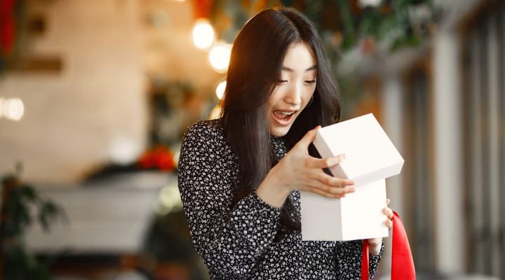 Group of young people opening christmas gifts