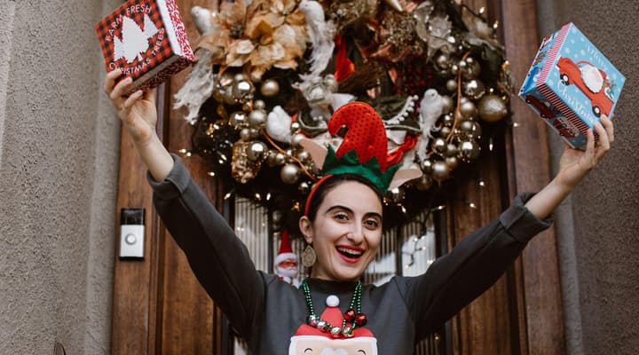 Woman dancing wearing christmas jumper and christmas tree headband