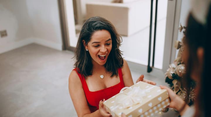 Woman looking surprised receiving a christmas gift