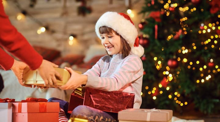 Young girl smiling receiving christmas gift