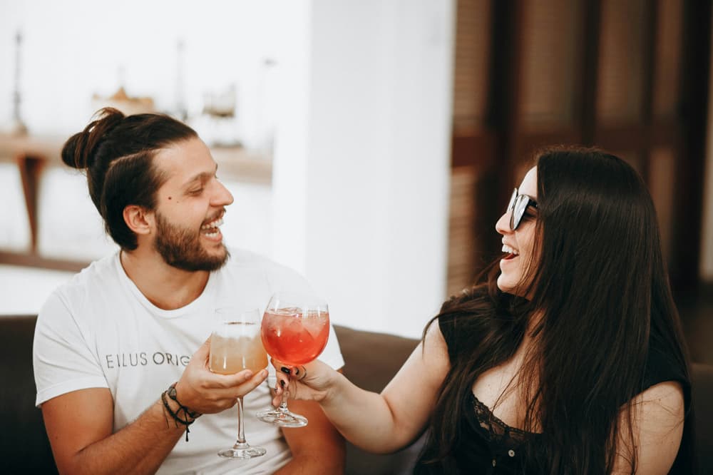 Man and woman holding a glass of red wine