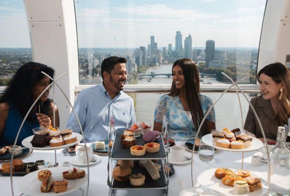 Four people around a table having afternoon tea on the london eye
