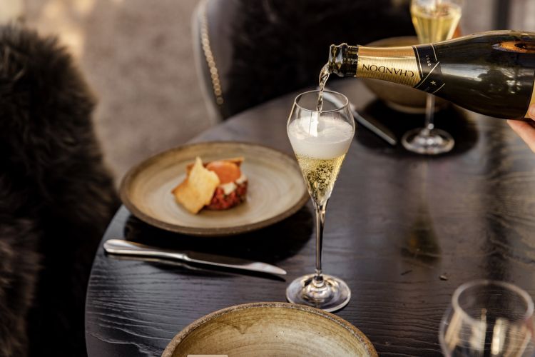 Pouring champagne into glass on table at gaucho