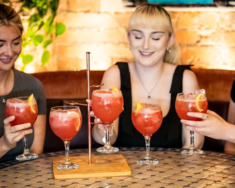 three ladies with a tipsy strawberry daiquiri cocktail tree at revolucion de cuba