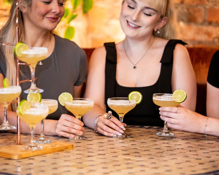 three ladies with a margarita cocktail tree at revolucion de cuba