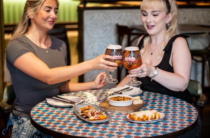 two ladies with beers and tapas dishes at revolucion de cuba