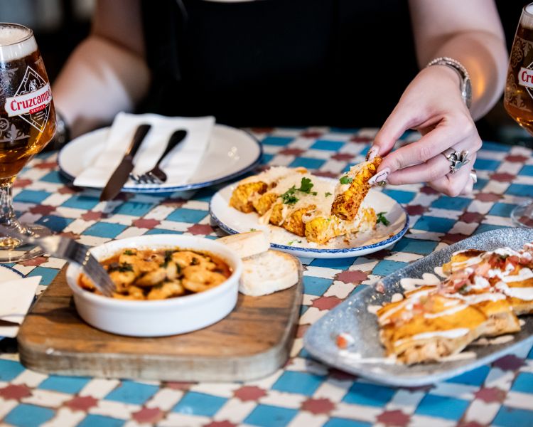 two ladies with tapas dishes at revolucion de cuba