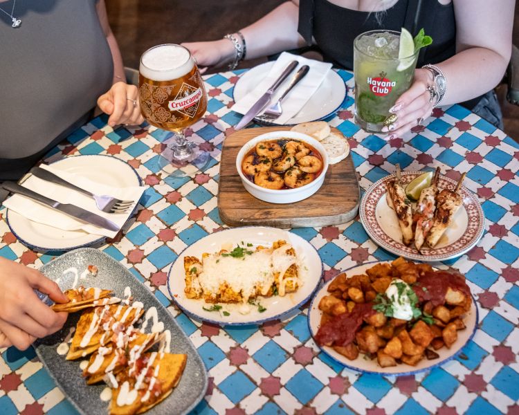 two ladies with bottomless drinks and tapas dishes at revolucion de cuba