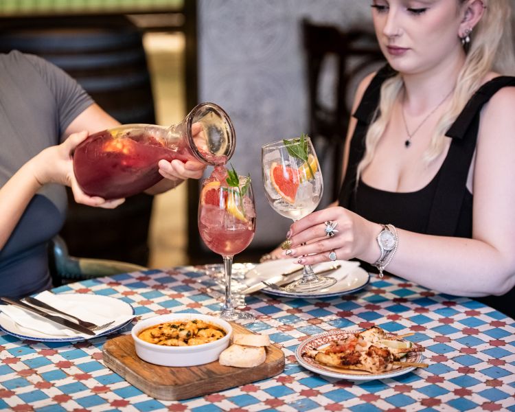 two ladies with jug of sangria and tapas at revolucion de cuba