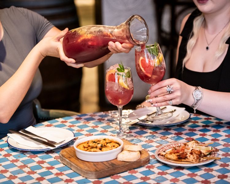 two ladies with jug of sangria and tapas at revolucion de cuba
