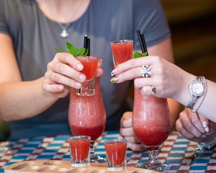 two ladies with strawberry daiquiris and margarita shots at revolución de cuba