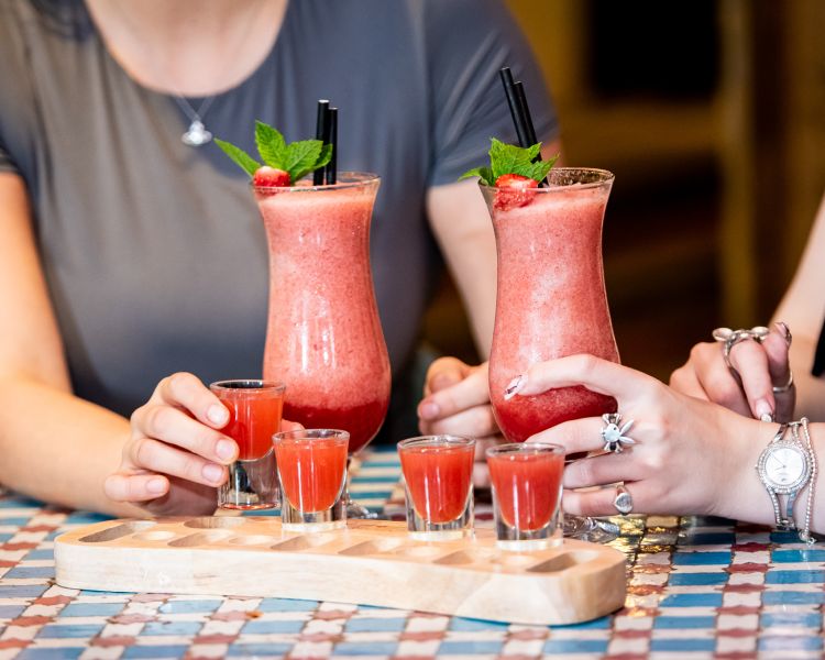 two ladies with strawberry daiquiris and margarita shots at revolución de cuba