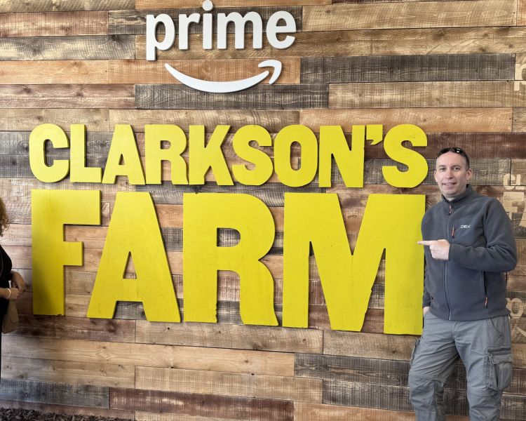 two people next to the clarkson's farm sign