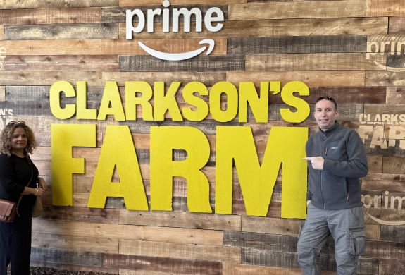 two people next to the clarkson's farm sign