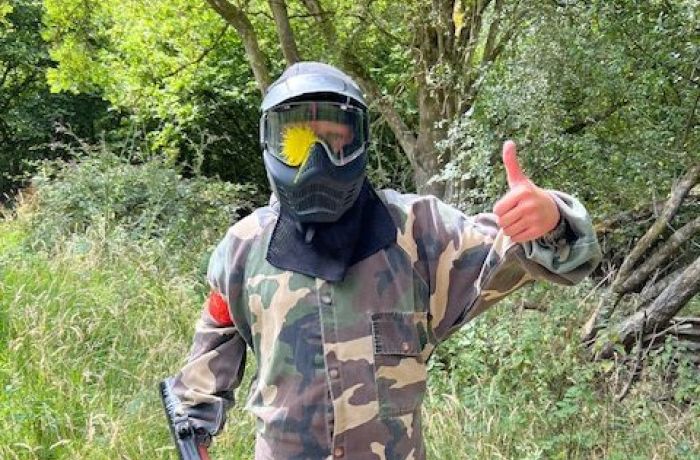 Person with thumbs up and paint on helmet