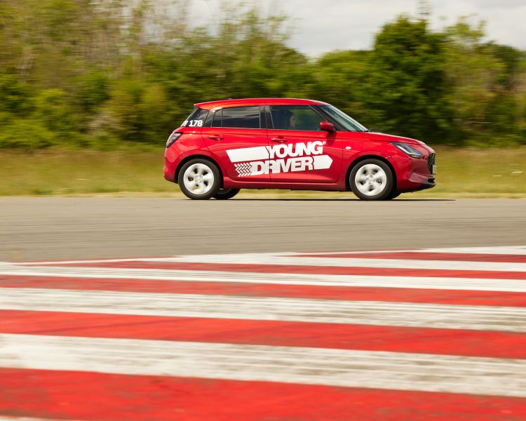 A red suzuki swift on the track