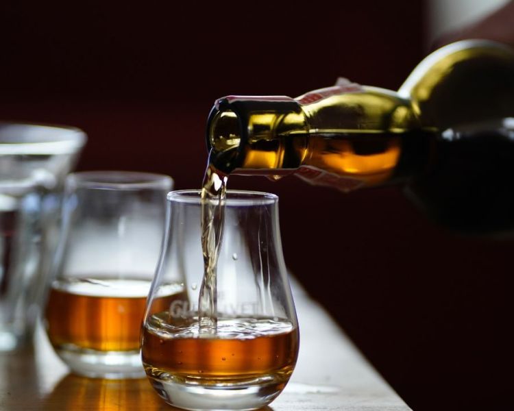 whisky being poured into a glass on a whisky tasting experience