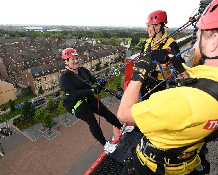 man about to abseil down the side of anfield stadium