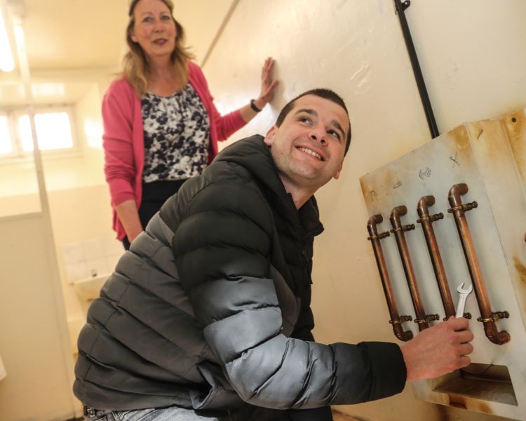 man and woman trying to solve puzzles in a prison cell on a prison escape room experience day