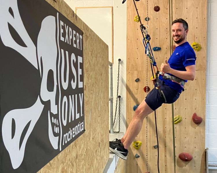 man abseiling down an indoor wall on an abseiling taster session in brighton