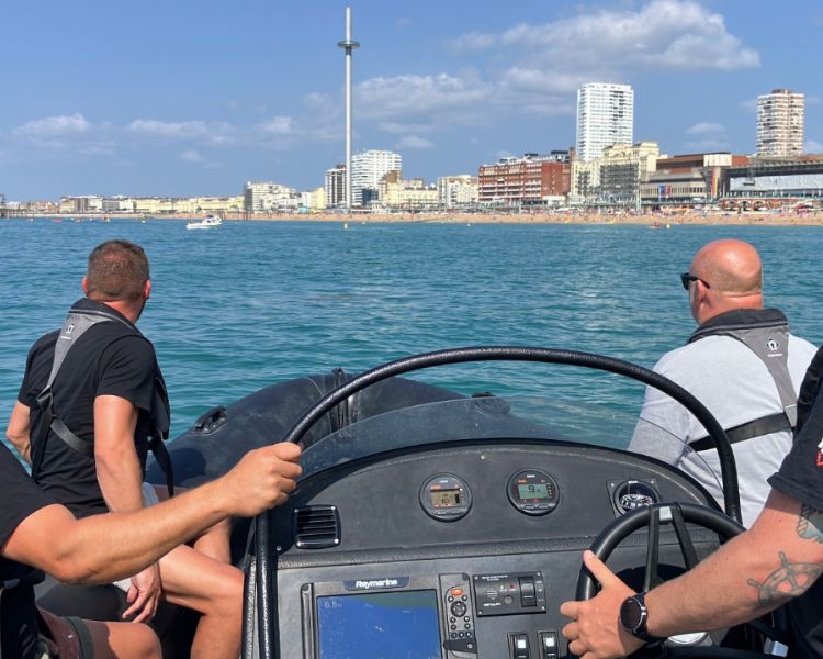 four people on powerboat looking towards brighton coast on a powerboat two day training course in brighton