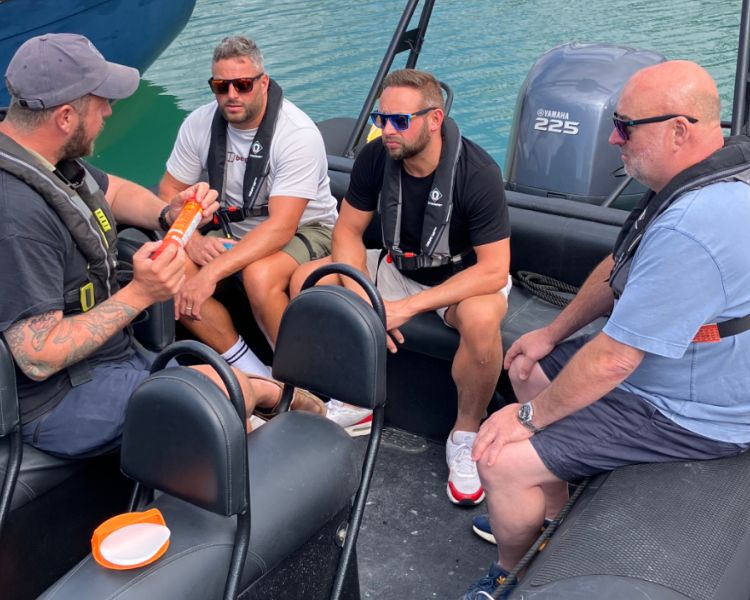 three men sitting in powerboat with instructor on a powerboat two day training course in brighton