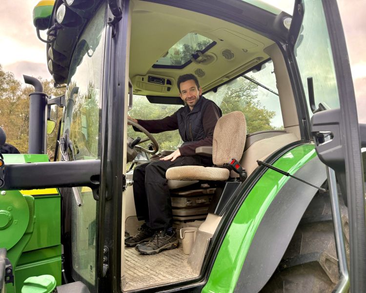 man sitting in cab of tractor on a tractor driving experience