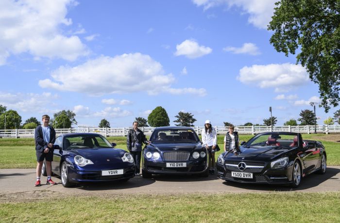 three young drivers stood by exclusive cars