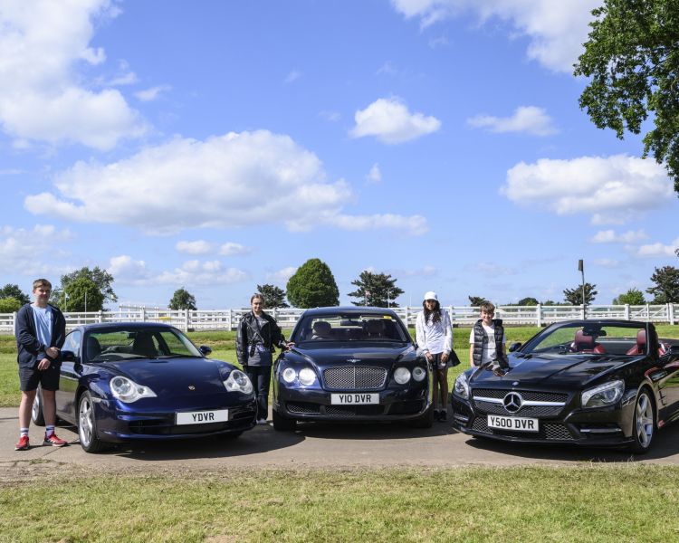 three young drivers stood by exclusive cars