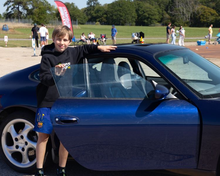 a young driver beside an exclusive collection car