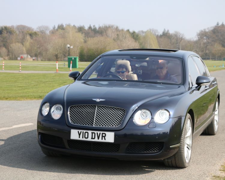 a young driver and instructor mid-session in an exclusive car