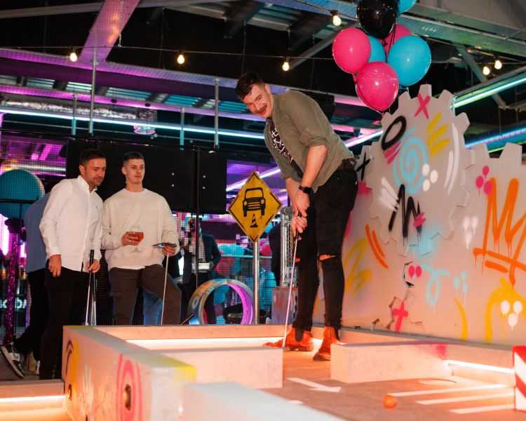 lads playing crazy golf at a boom battle bar