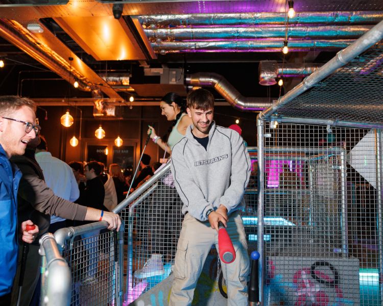 young men playing crazy golf at a boom battle bar