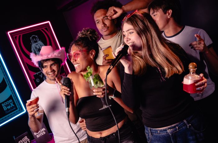 young people singing karaoke at a boom battle bar