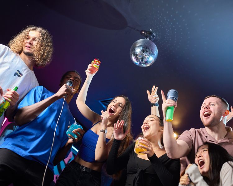 young people singing karaoke at a boom battle bar