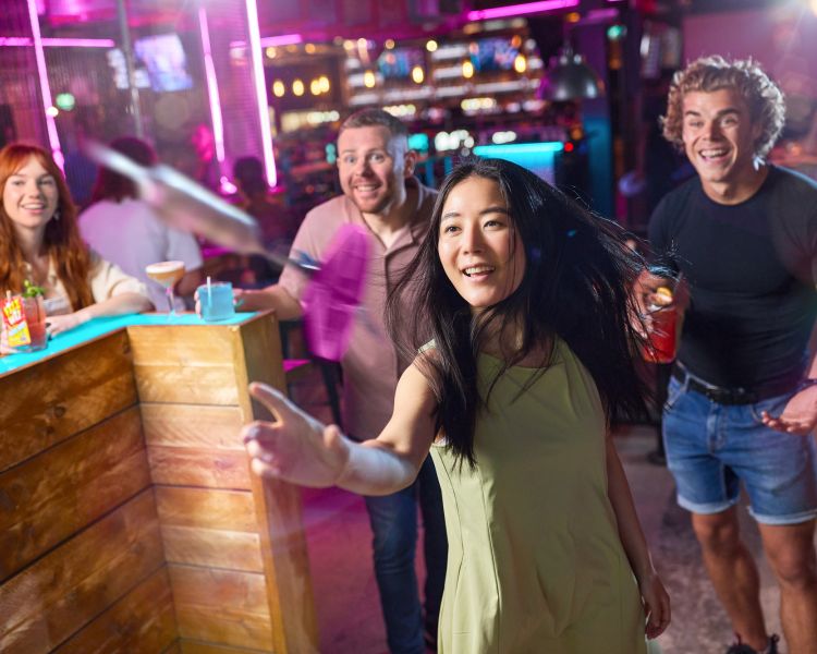 friends playing augmented reality darts at a boom battle bar