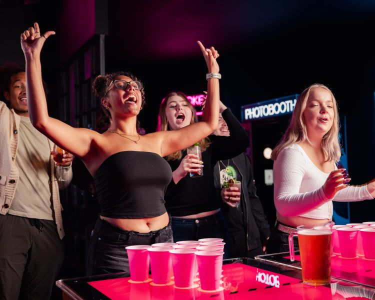 friends playing beer pong at a boom battle bar