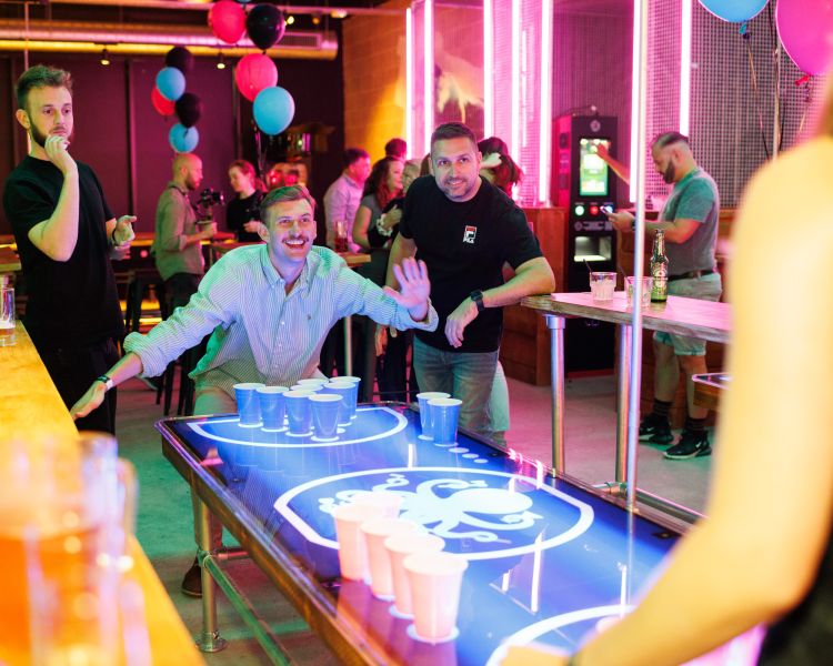 friends playing beer pong at a boom battle bar