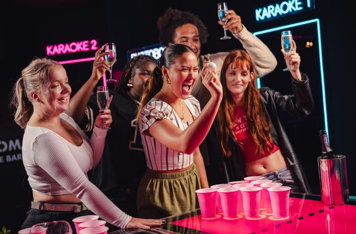 ladies playing prosecco pong at a boom battle bar